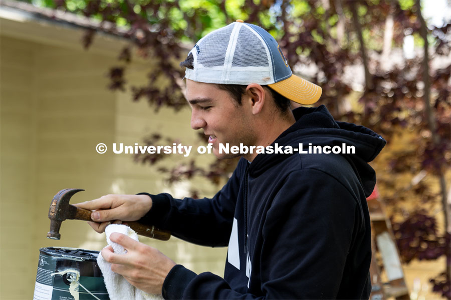 Ethan Bichler of Pi Kappa Alpha replaces the lid of a paint can during the Big Event. May 4, 2024. Photo by Kirk Rangel for University Communication.